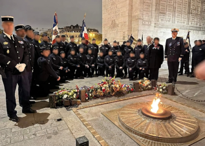 Groupe de cadets de la gendarmerie et représentants officiels réunis autour d’une flamme du souvenir lors d’une cérémonie commémorative.